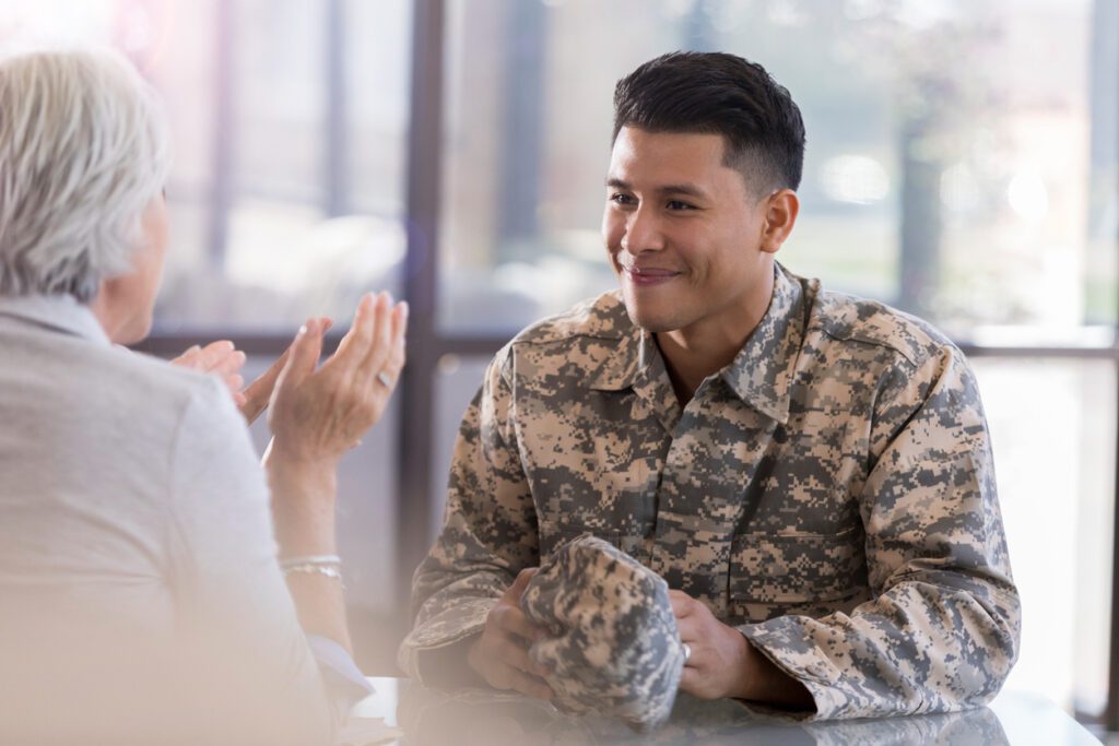 Young male in uniform smiles at counselor