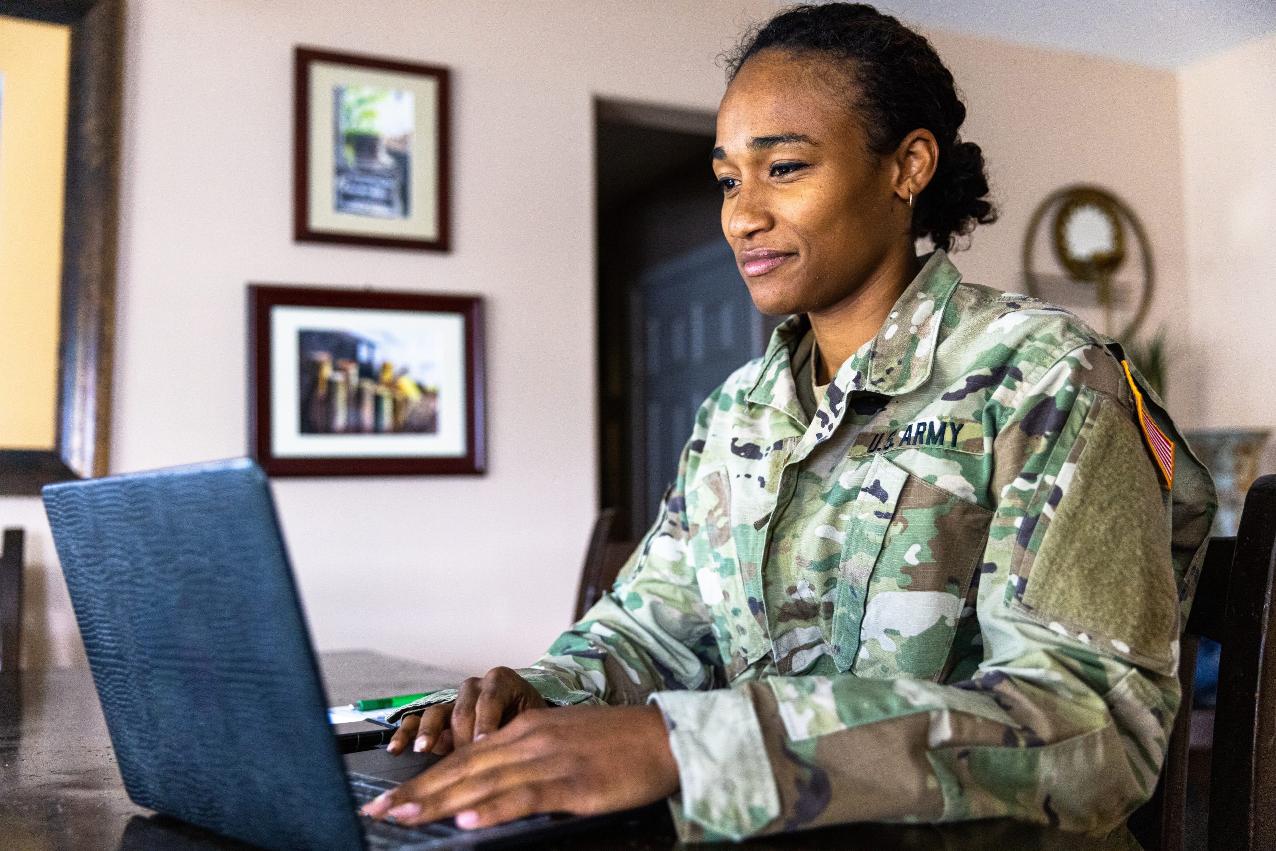 Young US Army Service member using laptop at home